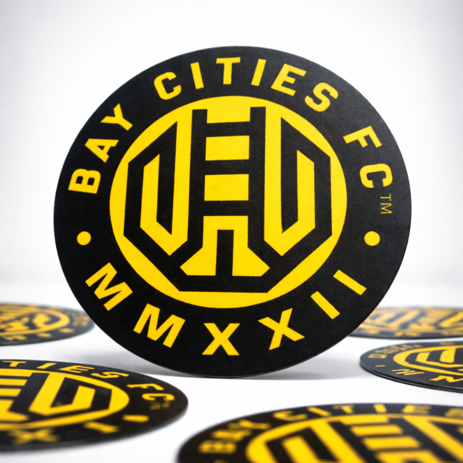 Bay Cities FC logo sticker on a black circular background with yellow text and design.