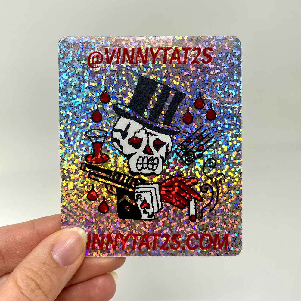 Custom holographic glitter sticker with a skull magician design, red lettering, and rounded square corners.