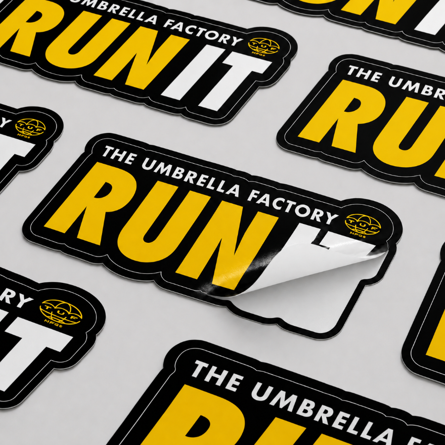 Custom Kiss-Cut Stickers with 'The Umbrella Factory Run' text on a gray background