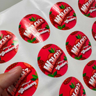 Sheet of custom round strawberry product labels with a glossy finish on white backing paper.