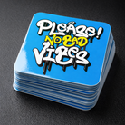 Stack of blue stickers with 'Please! No Bad Vibes' text on a dark surface