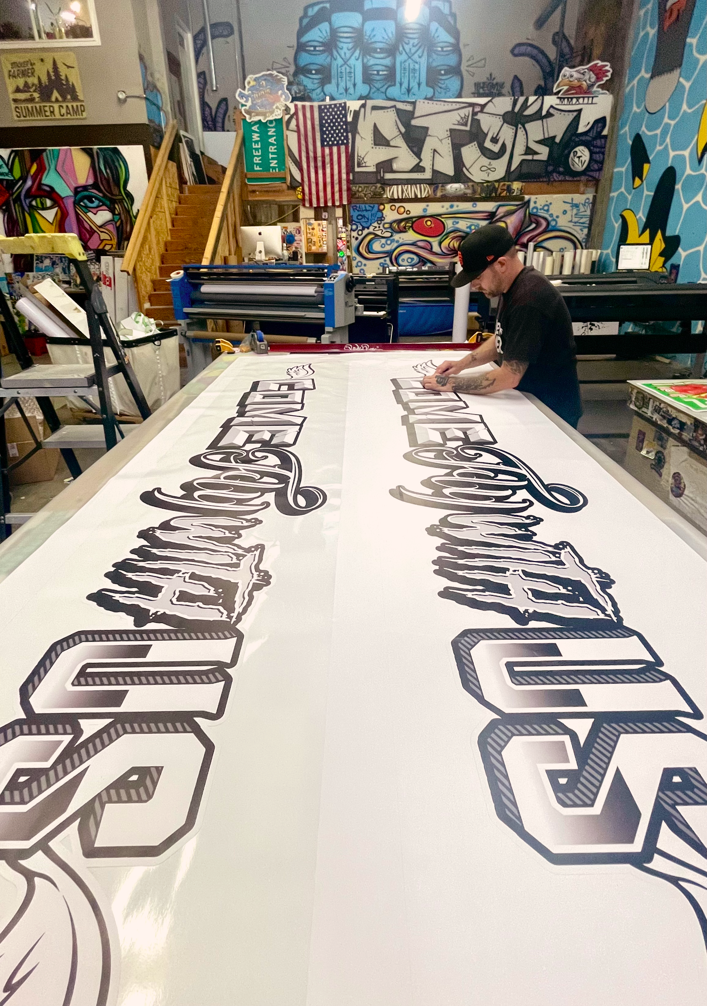 Person cutting out custom large format vinyl decal.