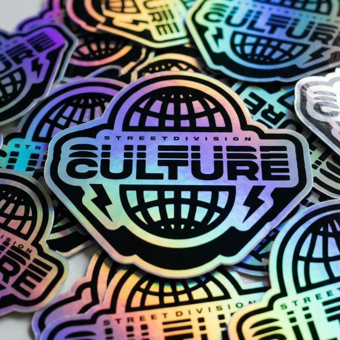 Custom holographic stickers featuring an iridescent rainbow finish and a black logo design.